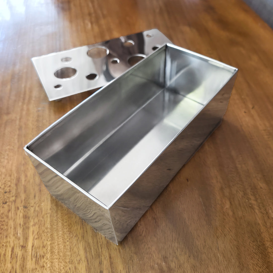 8-inch rectangular stainless steel Ikebana vase with a removable floral arrangement top on a wooden table.