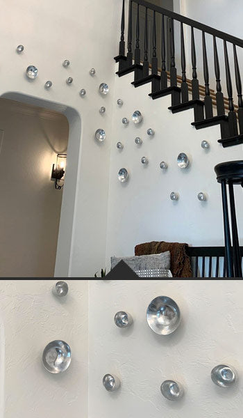 Silver Seed and Full Moon Wall Play™ in a home on a white wall under a stair with black bannister.